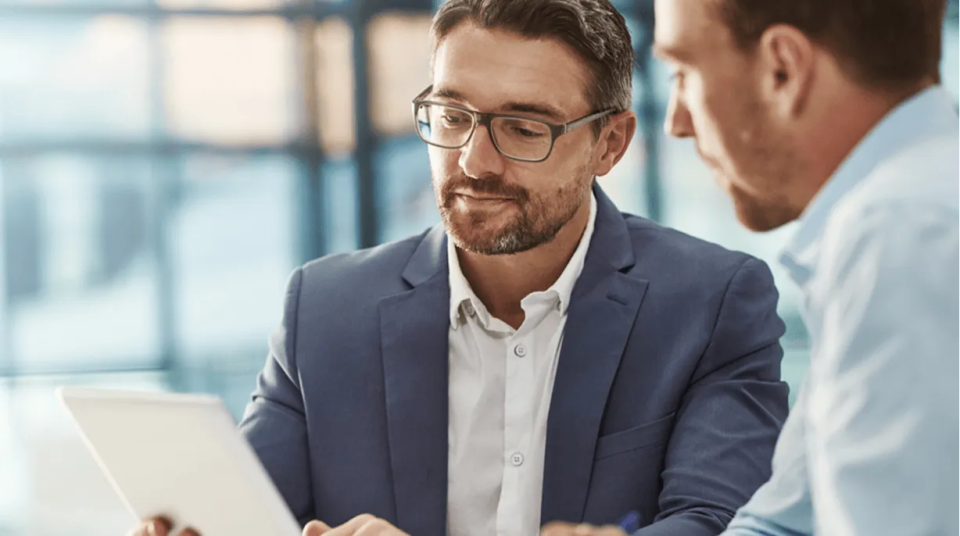 Ejecutivo usando tablet en reunión.